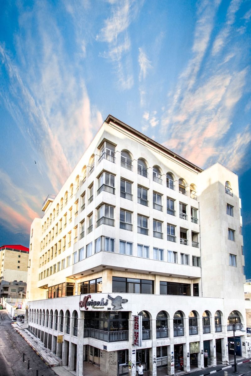 A multi-story hotel with a central courtyard and balconies.