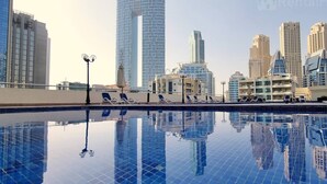 A rooftop pool with a clear view of modern high-rise buildings in the background. - Big Studio w/ Balcony and easy access to the Beach in Marina (Dubai)