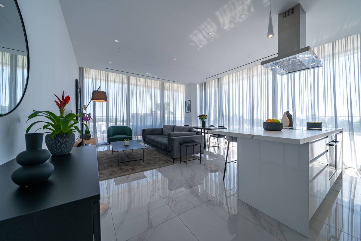 Una sala de estar moderna con un sofá, una mesa de centro y un comedor con isla de cocina.