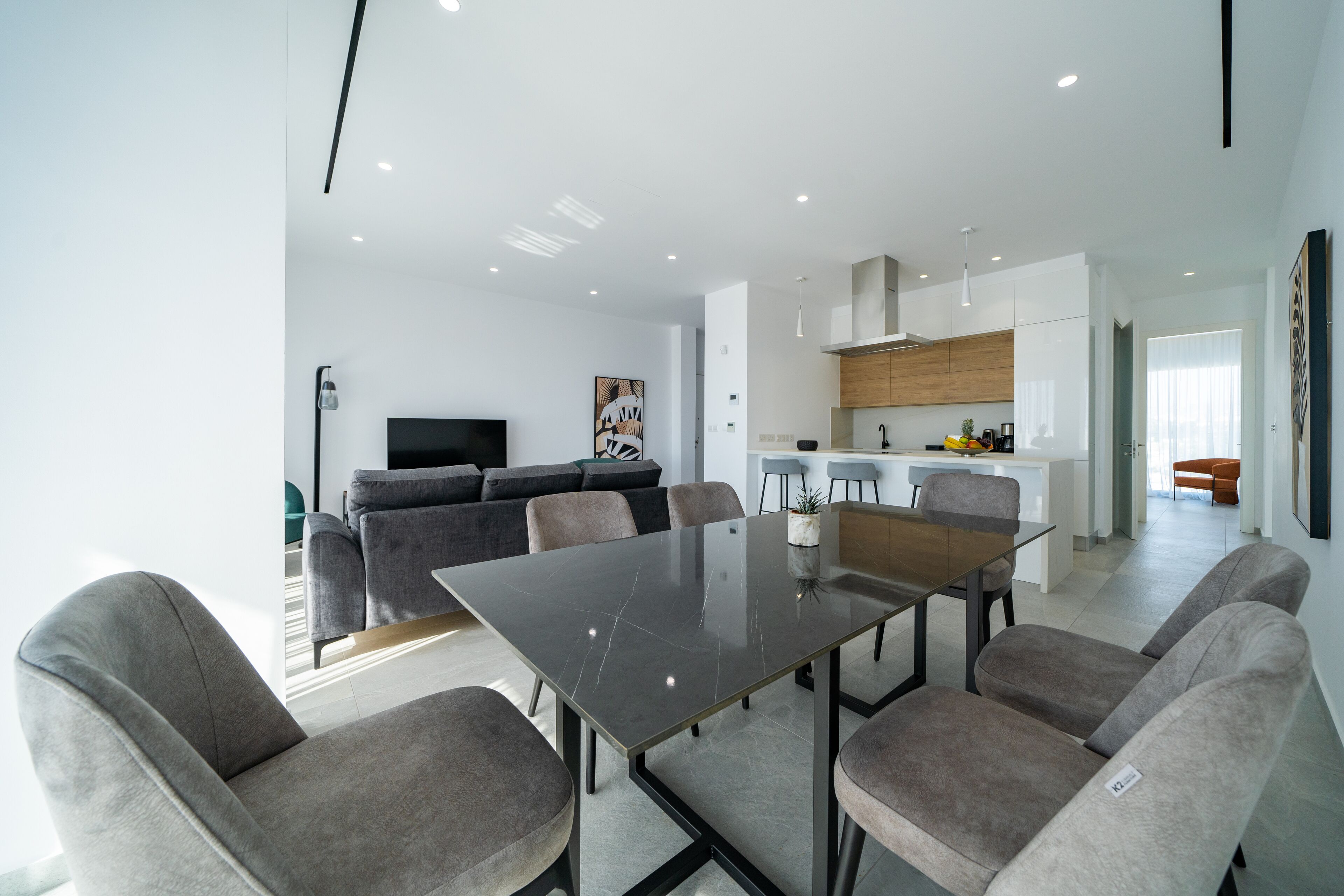 Un salon moderne comprenant un coin repas, une cuisine et un espace détente.