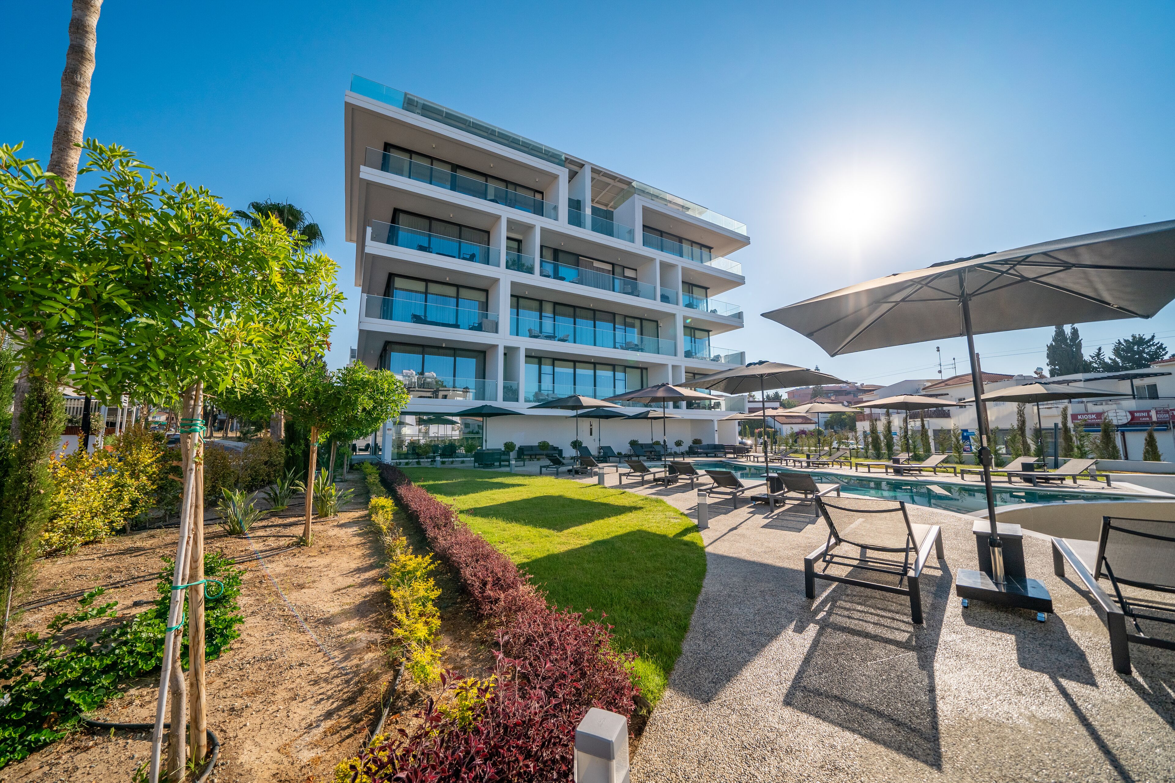Un hôtel moderne doté d’une piscine, d’un espace extérieur aménagé et d’un jardin bien entretenu.