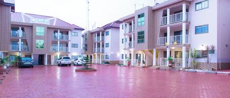 A hotel with a red-tiled courtyard, multiple balconies, and a sign reading "JANNABH".