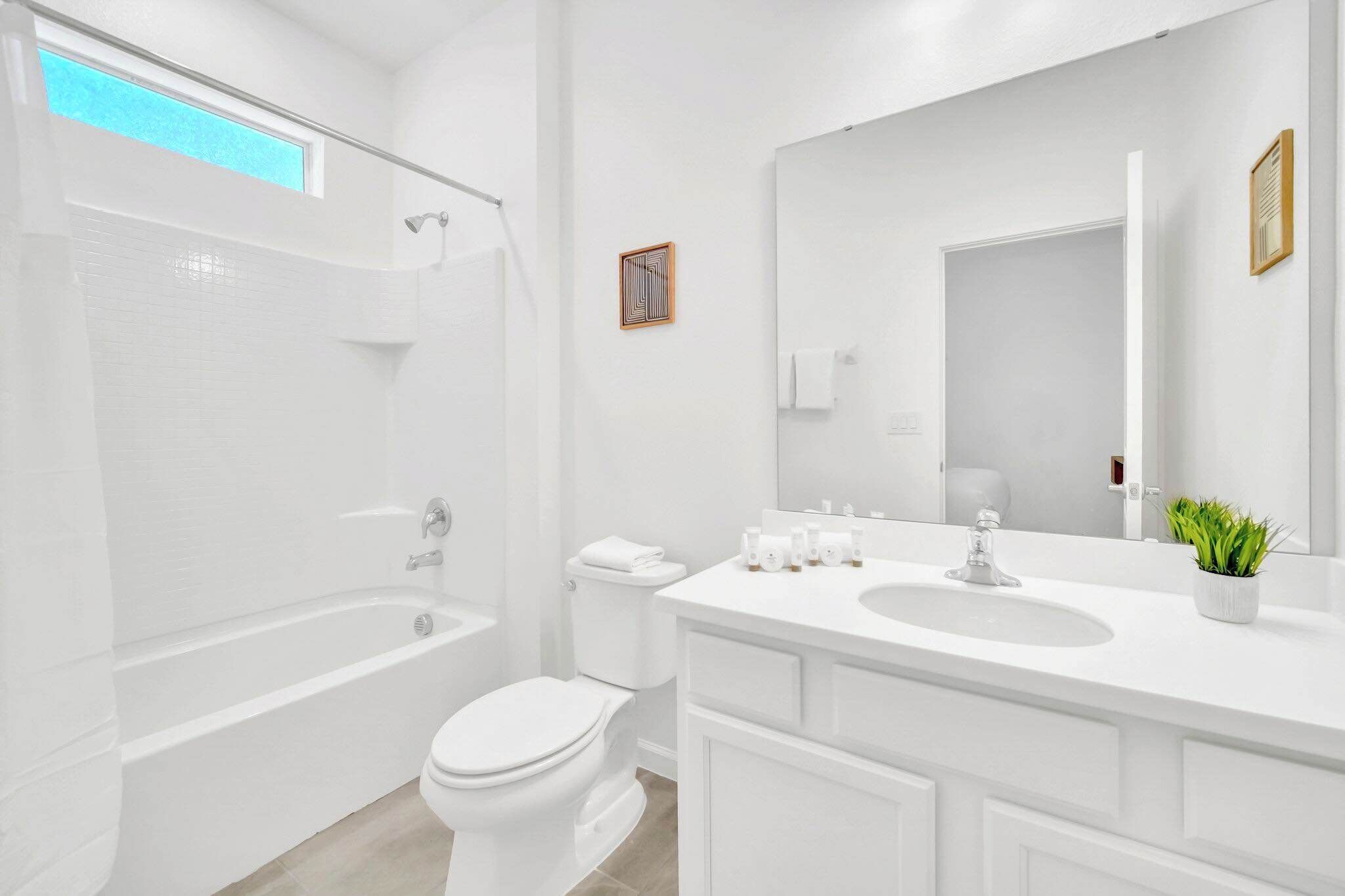 A modern bathroom with a bathtub, toilet, and sink.