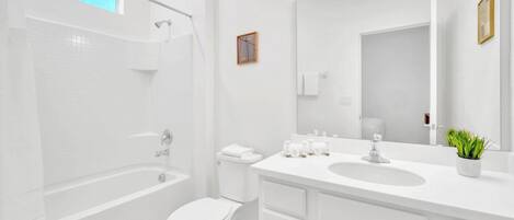 A modern bathroom with a bathtub, toilet, and sink.