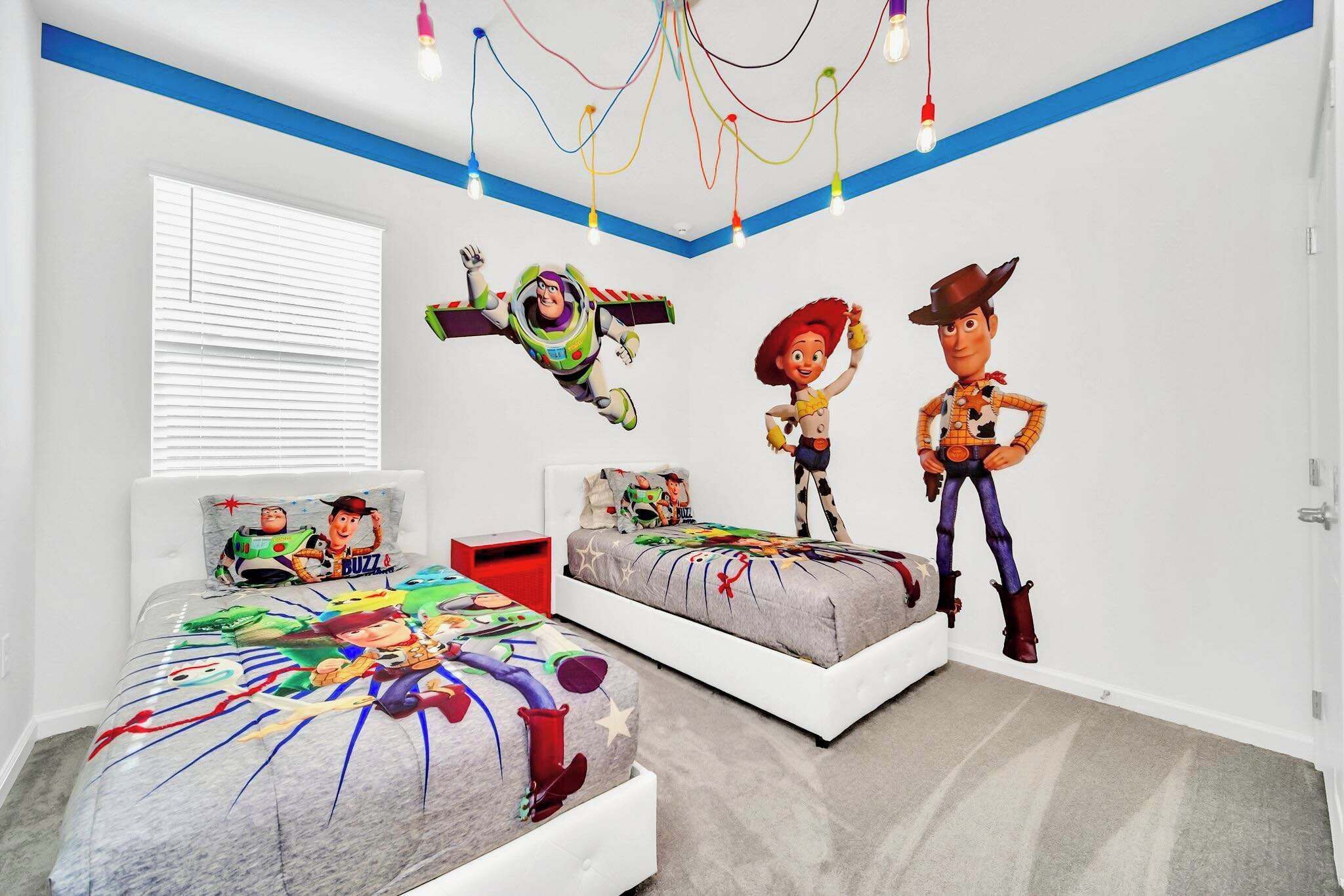 Et soveværelse med to senge, hver pyntet med Buzz Lightyear og Woody fra Toy Story.