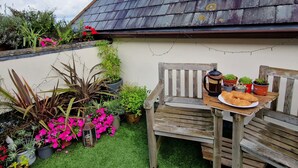 A wooden bench with a table, a coffee pot, and a plate of croissants. - Carnethic House Penthouse Apartment (Fowey)