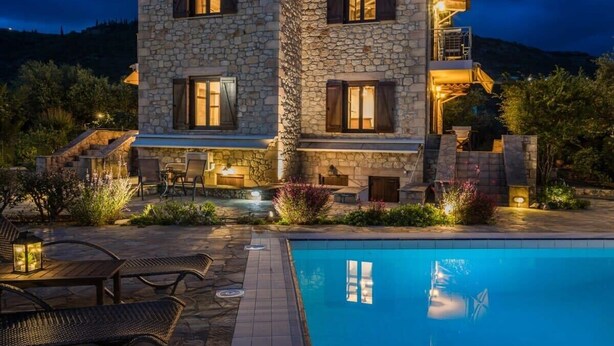 A stone building with a pool, outdoor seating, and a staircase leading to a balcony. - Eleonas Houses - Kardamili's  Bianca Poolside Gem (Kardamyli)