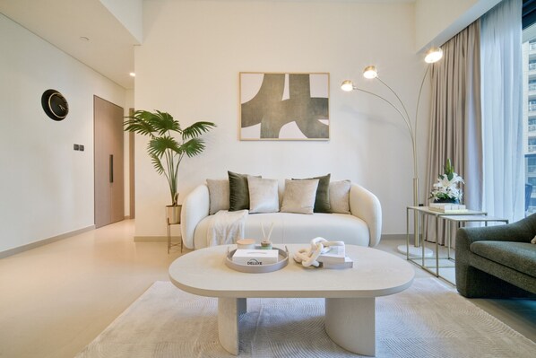 A modern living room with a sofa, a coffee table, a floor lamp, and a painting on the wall.