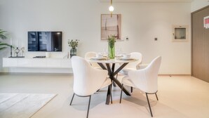 Un comedor moderno con una mesa redonda, sillas blancas y una lámpara colgante.