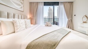 Habitación de hotel con una cama grande, vistas a edificios altos y un diseño moderno.