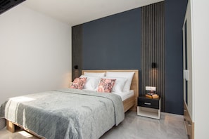 Una camera da letto moderna con un letto, un comodino e una lampada.