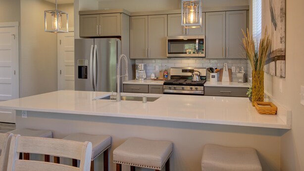 A modern kitchen with a central island, stainless steel appliances, and pendant lighting. - Vitamin Sea - Oyhut Bay Seaside Village (Ocean Shores)