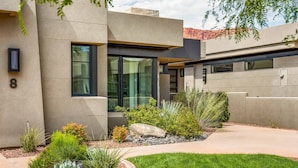 A modern house with a well-maintained garden, large windows, and a number '8' sign. - Snow Canyon Sanctuary #8 4 Bedroom Home (Ivins)