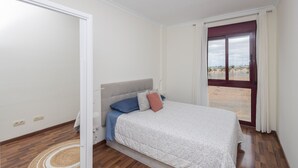 A bedroom with a bed, a window with curtains, and a view of the outside. - Luxury Workfriendly Home - Far Ocean Views (Santa Lucía de Tirajana)