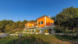 A two-story house with a stone foundation, orange walls, and a balcony. - Agriturismo Cascina Trevo (Spotorno)