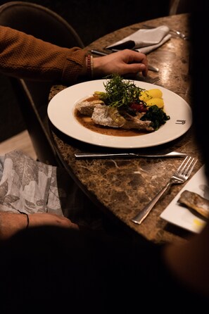 Une table à manger avec une assiette de nourriture, une fourchette et un couteau.