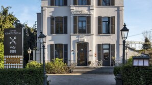 Een hotel met twee verdiepingen, met een bord waarop 'Hotel Groenendaal' staat.