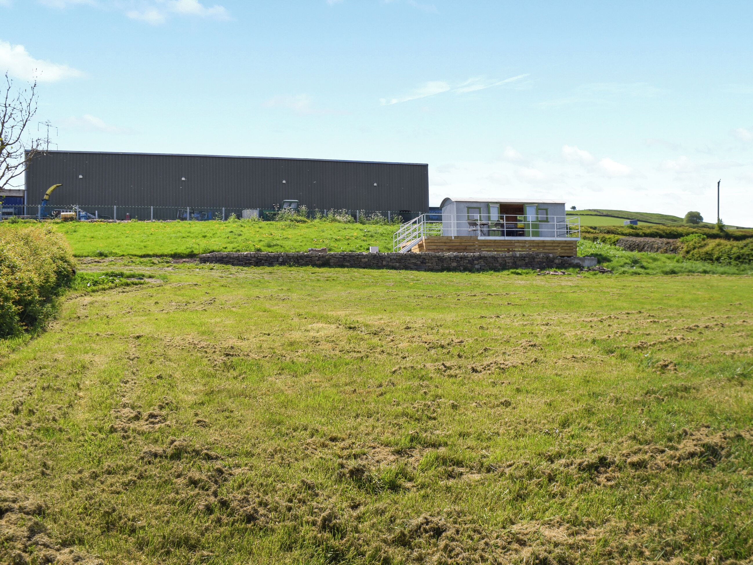 A large industrial building with a modern extension featuring a covered outdoor area.