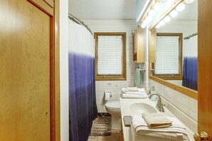 A bathroom with a bathtub, toilet, and sink. - Pet-friendly Waterloo Abode w/ Deck! (Waterloo)