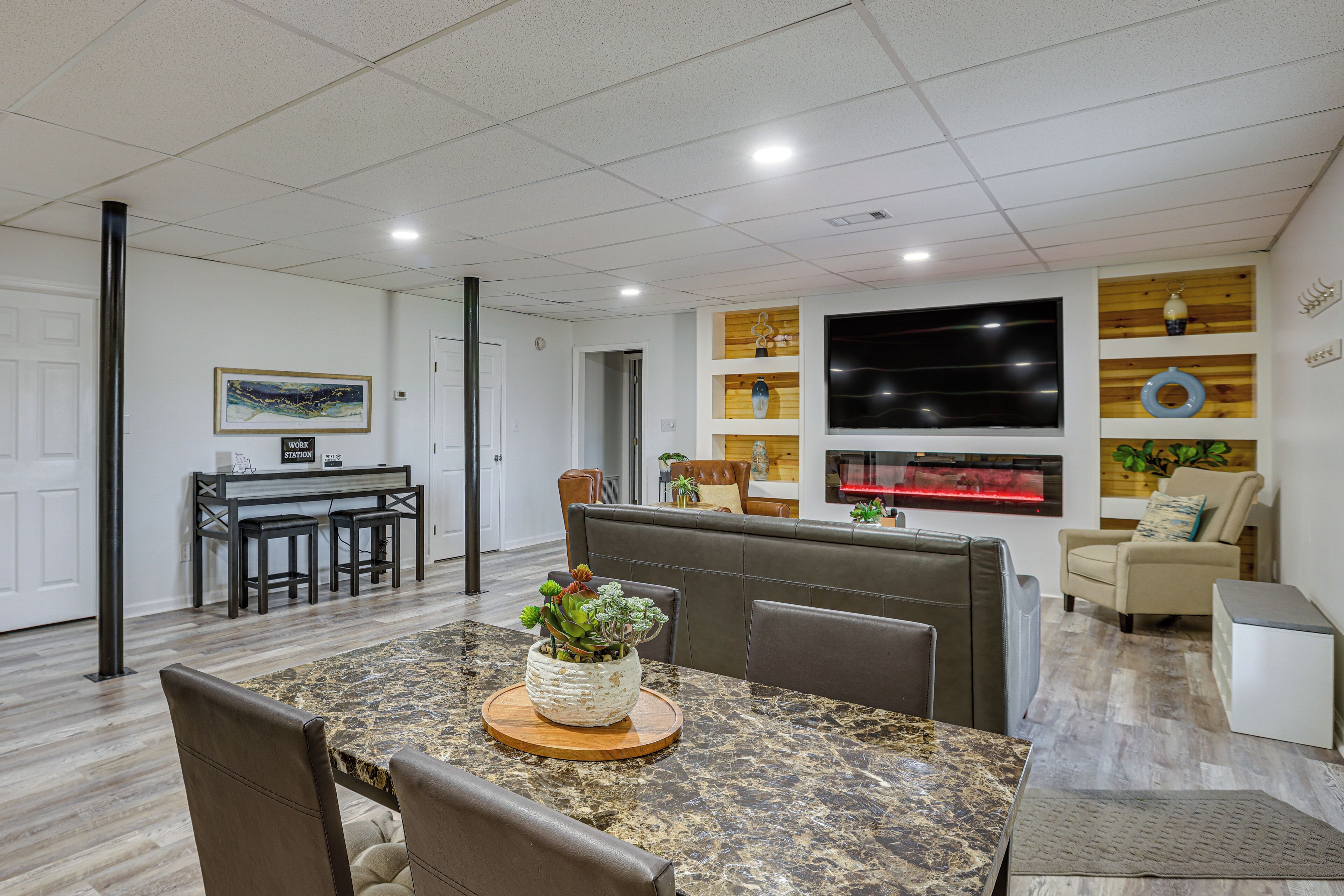 Una sala de estar moderna con comedor, chimenea y televisor.