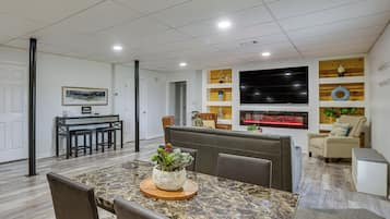 Una sala de estar moderna con comedor, chimenea y televisor.