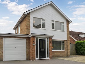 A two-story house with a garage, a front door, and a brick facade. - 3 bedroom accommodation in Bridlington (Bridlington)
