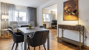 Un salon moderne avec un coin repas, comprenant un canapé, une table à manger et un téléviseur.