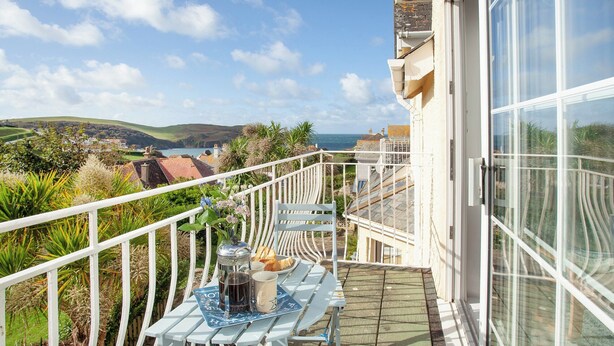 A balcony with a table set for two, overlooking a scenic coastal view. - 3 bedroom accommodation in Hope Cove, near Kingsbridge (Hope Cove, near Kingsbridge)
