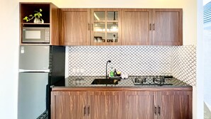 Una cocina moderna con armarios de madera, microondas integrado y un salpicadero con diseño.