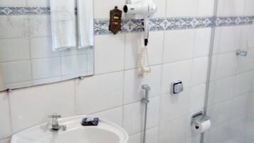 Een haardroger, handdoeken, zeep, toiletpapier