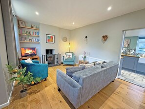 A living room with a fireplace, a sofa, a TV, and a bookshelf.