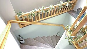 Eine Wendeltreppe mit Holzgeländern und Grünpflanzen.