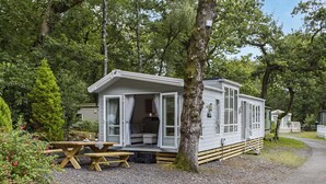 Une maison mobile dotée d’une véranda et d’une table de pique-nique.