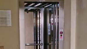 En elevator med metalvægge og et kontrolpanel med knapper.