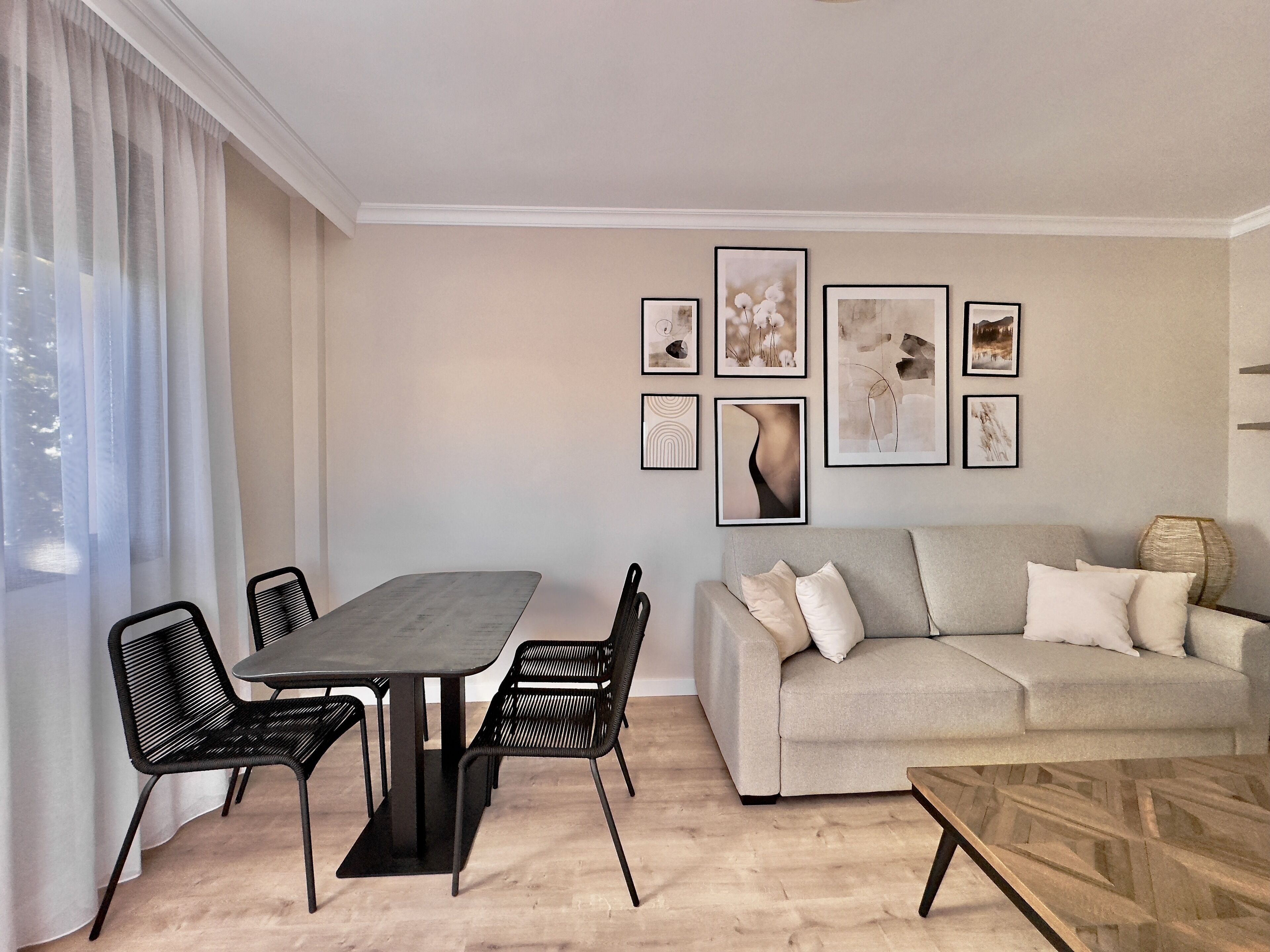 Ein modernes Wohnzimmer mit Essbereich, ausgestattet mit einer Couch, einem Couchtisch und einem Esstisch mit Stühlen.