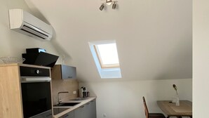 Et kompakt køkken med ovenlys, spiseplads og et indbygget ovn.