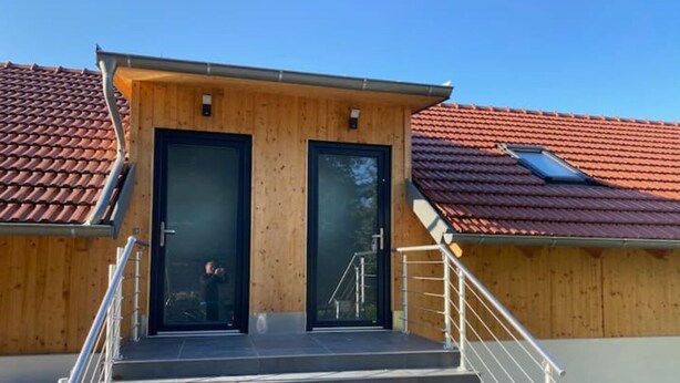 En træbygning med en trappe, der fører op til en dør.