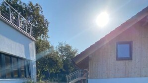 En sti der fører hen til en bygning med facade af træ og en garage.