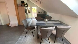 A dining area with a table, four chairs, and a rug. - roof terrace flat "Alois" (Passau)