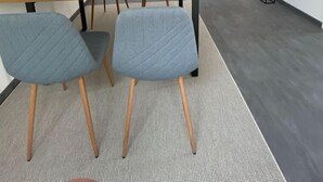 A modern kitchen with a built-in oven and microwave, a dining area with a wooden table and two chairs, and a small potted plant. - holiday flat "Valentin" (Passau)
