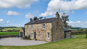 A stone house with a gravel driveway and a fenced yard. - 3 bedroom accommodation in Lancaster (Lancaster)