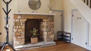 A stone fireplace with a mirror above, a wicker basket, and a coat rack with a heart-shaped ornament. - 3 bedroom accommodation in Lancaster (Lancaster)