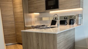 Une cuisine moderne avec des meubles en bois, un îlot central et des appareils électroménagers intégrés.