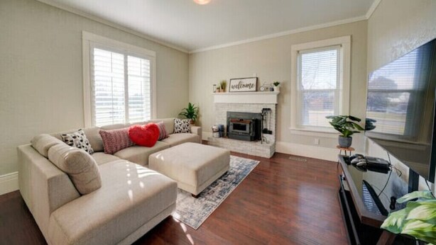 A living room with a beige sofa, a fireplace, and a TV.