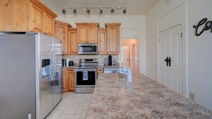 A kitchen with wooden cabinets, stainless steel appliances, and a granite countertop.