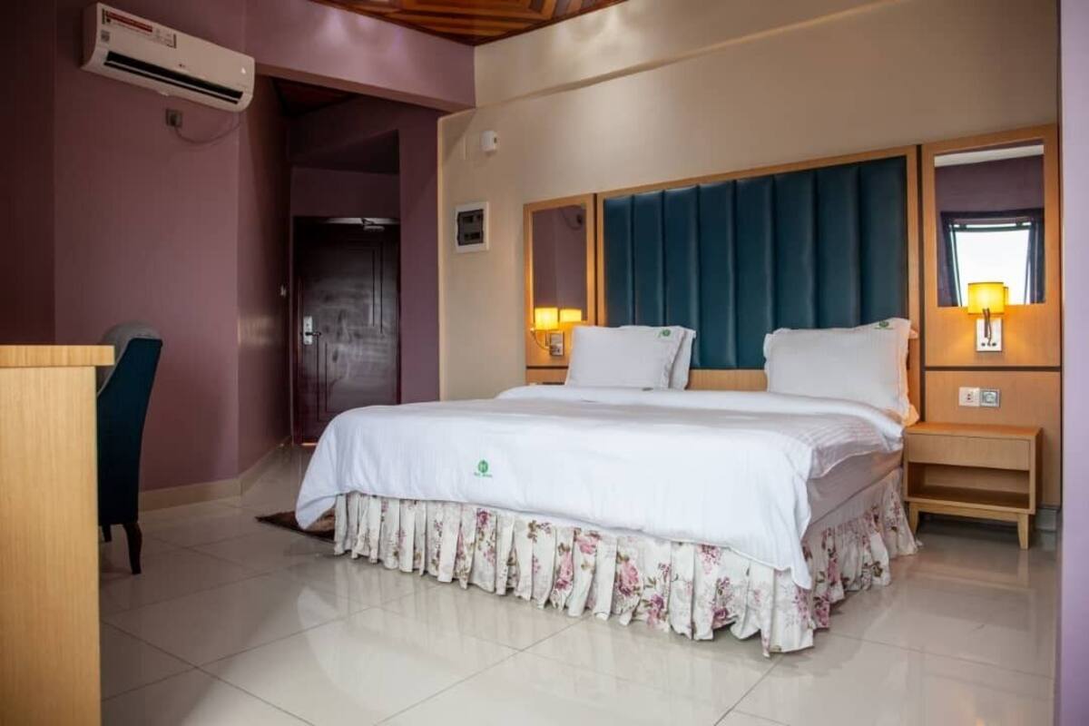 A hotel room with a bed, a desk, and a chair.