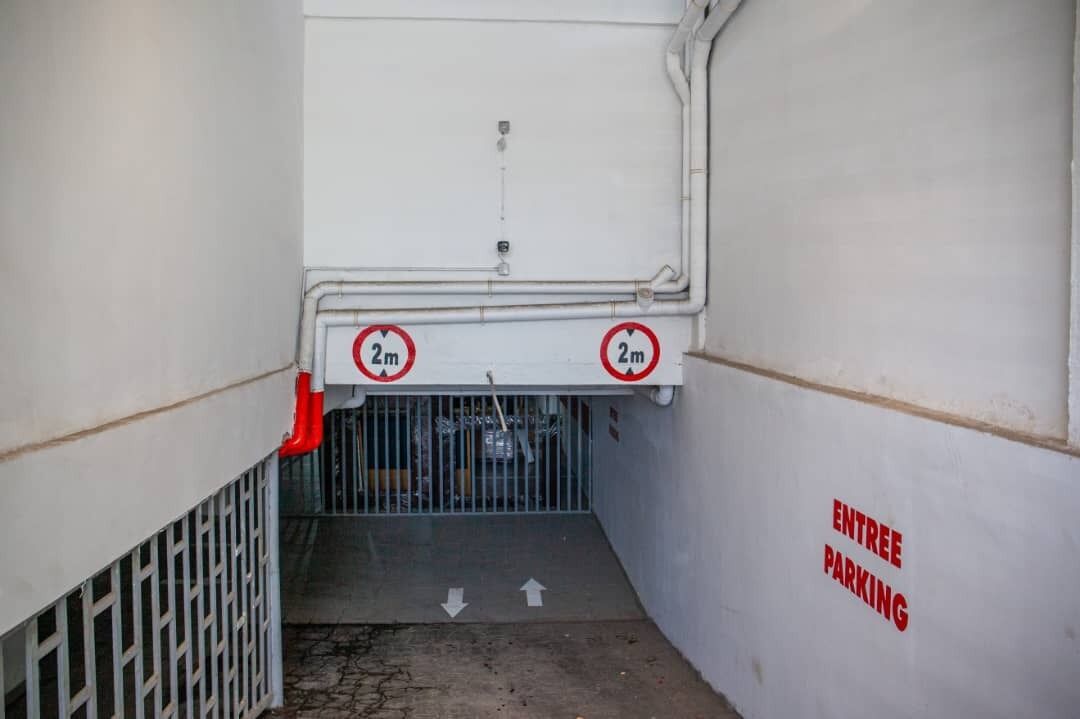 An entrance with a 2m height limit and an arrow pointing downwards.