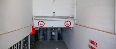 An entrance with a 2m height limit and an arrow pointing downwards.
