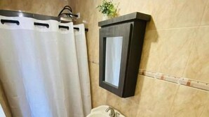 Un baño con lavamanos pedestal, inodoro y un pequeño cubo de basura.