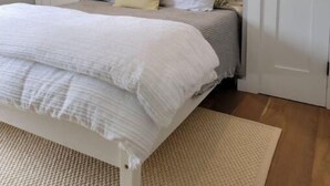 A bedroom with a bed, a bedside table, a mirror, and a door. - Lake Getaway at Coventry Lake! close to Uconn (Coventry)